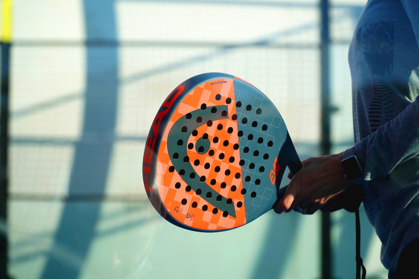 Players meeting at the net on a clay padel court